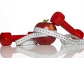 Red Dumbbells, fresh red apple and white measuring tape Royalty Free Stock Photo