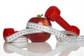 Red Dumbbells, fresh red apple and white measuring tape Royalty Free Stock Photo