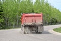 Red Dump Truck Driving Down Curvy Road