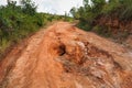 Red dust and mud road in poor condition with large holes and bumps formed after rain. Routes to Andringitra national park are Royalty Free Stock Photo