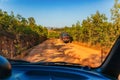 Red dust and mud road in poor condition with large holes Royalty Free Stock Photo