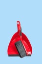 Red dustpan with brush on pastel blue background Royalty Free Stock Photo