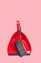 Red dustpan with brush on pastel pink background Royalty Free Stock Photo