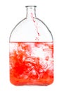 Red dye dissolves in water in glass flask isolated Royalty Free Stock Photo