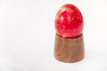 Red Easter boiled egg on a wooden pedestal