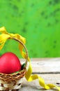 Red easter egg in basket with ribbon Royalty Free Stock Photo