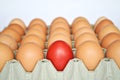 Red Easter egg among brown eggs Royalty Free Stock Photo