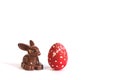 Red Easter egg on a white background, next to the Easter Bunny. Royalty Free Stock Photo