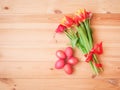 Red Easter eggs and tulip flowers with red ribbon on wooden background Royalty Free Stock Photo