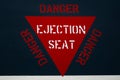 Red ejector seat warning sign on jet fighter aeroplane fuselage. Danger alert message for ejection of pilot. Royalty Free Stock Photo