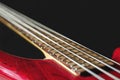 Red electric bass guitar with four strings on dark background Royalty Free Stock Photo