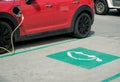 Red electric car at charging station with the power cable supply Royalty Free Stock Photo