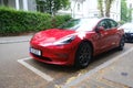 red electric car parked on street, popular sedan from company Elon Musk, alternative energy development concept, clean energy,