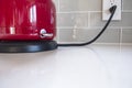 Red Electric Kettle Is Plugged In and Turned On to Boil Water