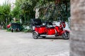 Red electric rickshaw or e-rickshaw commercial vehicle display with selective focus under daylight at kemer, turkey. Rent