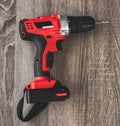 red electric screwdriver close up lying on a wooden table