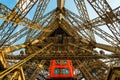 Red elevator brings tourists down the shaft in the metal Eiffel tower structure in Paris.