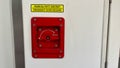 A red emergency door release button with a yellow sticker on it Royalty Free Stock Photo