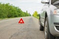 Red emergency stop sign and broken silver car on the road Royalty Free Stock Photo