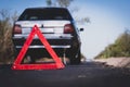 Red emergency stop sign close up on the road against the background of a broken car Royalty Free Stock Photo