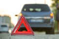 Red emergency triangle stop sign and broken car on a city street Royalty Free Stock Photo