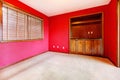 Red empty room with window and buil in cabinet.