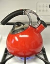 tea kettle red enamel whistling on a stove top boiling water Royalty Free Stock Photo