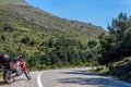 A red enduro motorcycle stands in side of the asphalt road, green nature