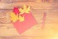 Red envelope with autumn leaves. Autumn letter. Maple leaves in red envelope, red pen on wooden background. Fall season. Autumn ho Royalty Free Stock Photo