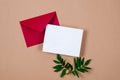 Red envelope with empty white card for text on beige background Royalty Free Stock Photo