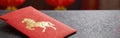 Red envelope with golden horse design on dark surface Royalty Free Stock Photo