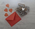 a red envelope made of paper. paper hearts. the heart is made of wooden branches