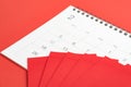 Red envelopes on February calendar on red background using as Ch