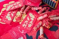 Red envelopes and firecracker ornaments scattered on red spring couplets background.The Chinese character on the red envelope mean