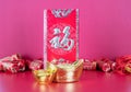 Red envelopes and gold ingot ornaments in the lively festive background.The Chinese characters in the picture mean `happiness`