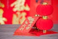 Red envelopes and small lanterns in front of the red couplet