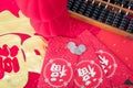 Red envelopes and traditional abacus and red lanterns and coins on red spring couplets background. The Chinese character on the re
