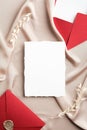 Red envelopes with wax seal and blank wedding invitation card mockup on satin fabric. Flat lay, top view, copy space. Wedding Royalty Free Stock Photo