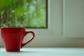 The red espresso cup on white windowsill. On background window and rain. Royalty Free Stock Photo