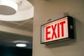 Red EXIT sign with white background, ceiling light fixture, and circular light Royalty Free Stock Photo