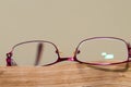 Red eyeglass on aged , orange book page close up macro shot Royalty Free Stock Photo