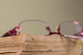 Red eyeglass on aged , orange book page close up macro shot, copy space Royalty Free Stock Photo