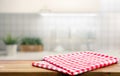 Red fabric,cloth on wood table top on blur kitchen counter roombackground.For montage product display or design key visual