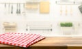 Red fabric,cloth on wood table top on blur kitchen counter roombackground