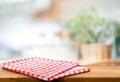 Red fabric,cloth on wood table top on blur kitchen counter roombackground