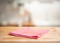 Red fabric,cloth on wood table top on blur kitchen counter roombackground