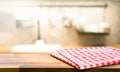 Red fabric,cloth on wood table top on blur kitchen counter roombackground