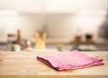 Red fabric,cloth on wood table top on blur kitchen counter roombackground