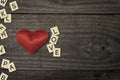 Red fabric heart on wooden table along with the word love