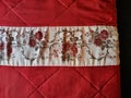 Red fabric from a plaid or blanket and embroidery of flowers. Background, texture, pattern, frame, copy space and place Royalty Free Stock Photo